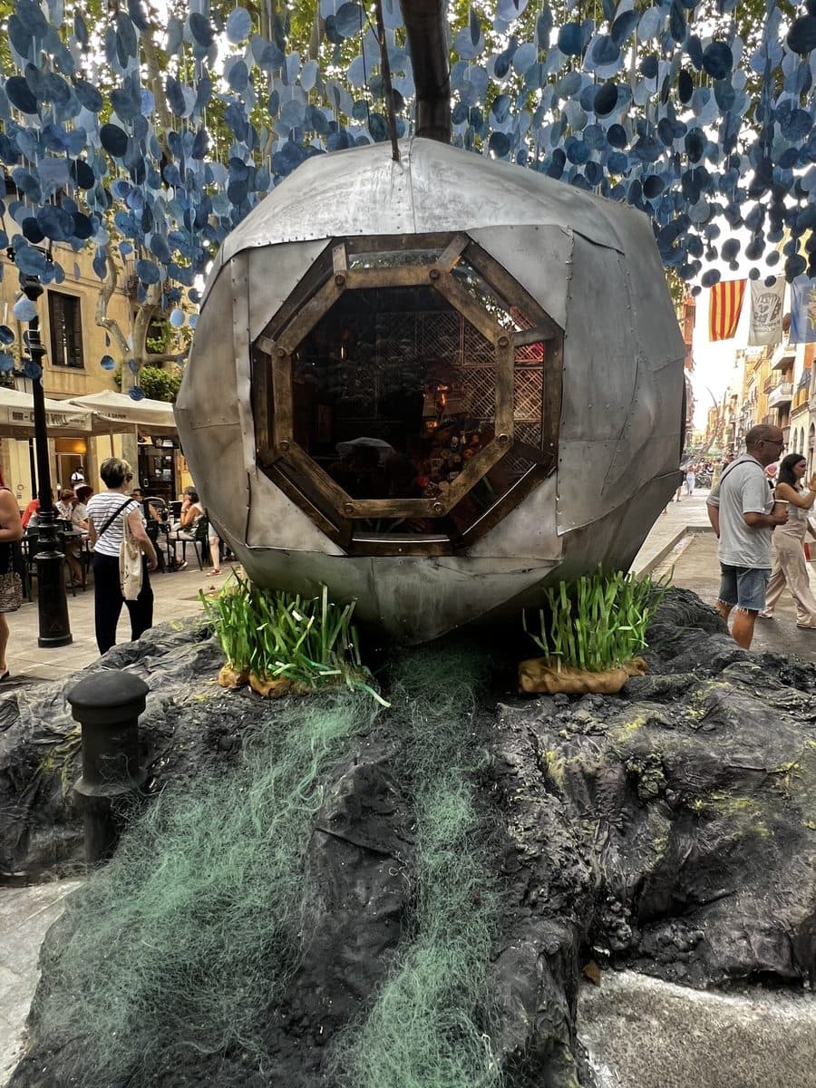 A decorated street during the Festa Major de Gràcia, hung with thousands of paper fish